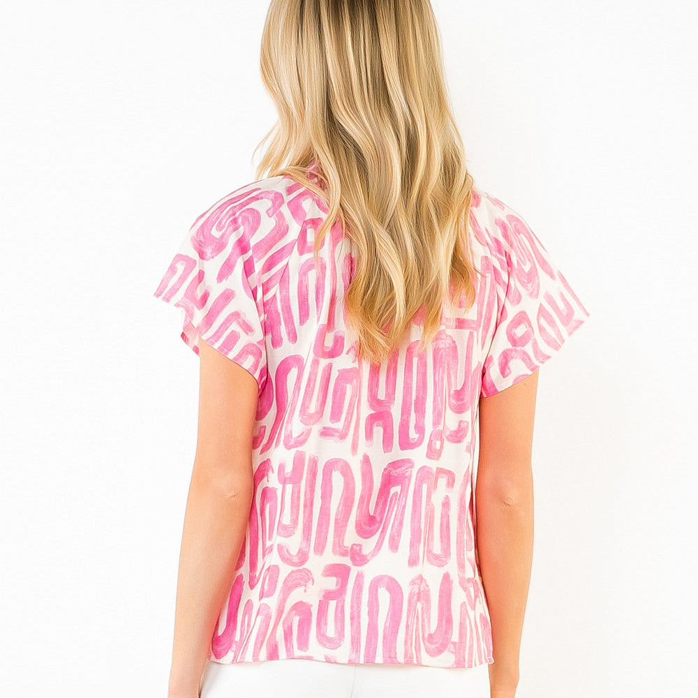 Woman wearing a pink and white patterned top with white shorts on a white background