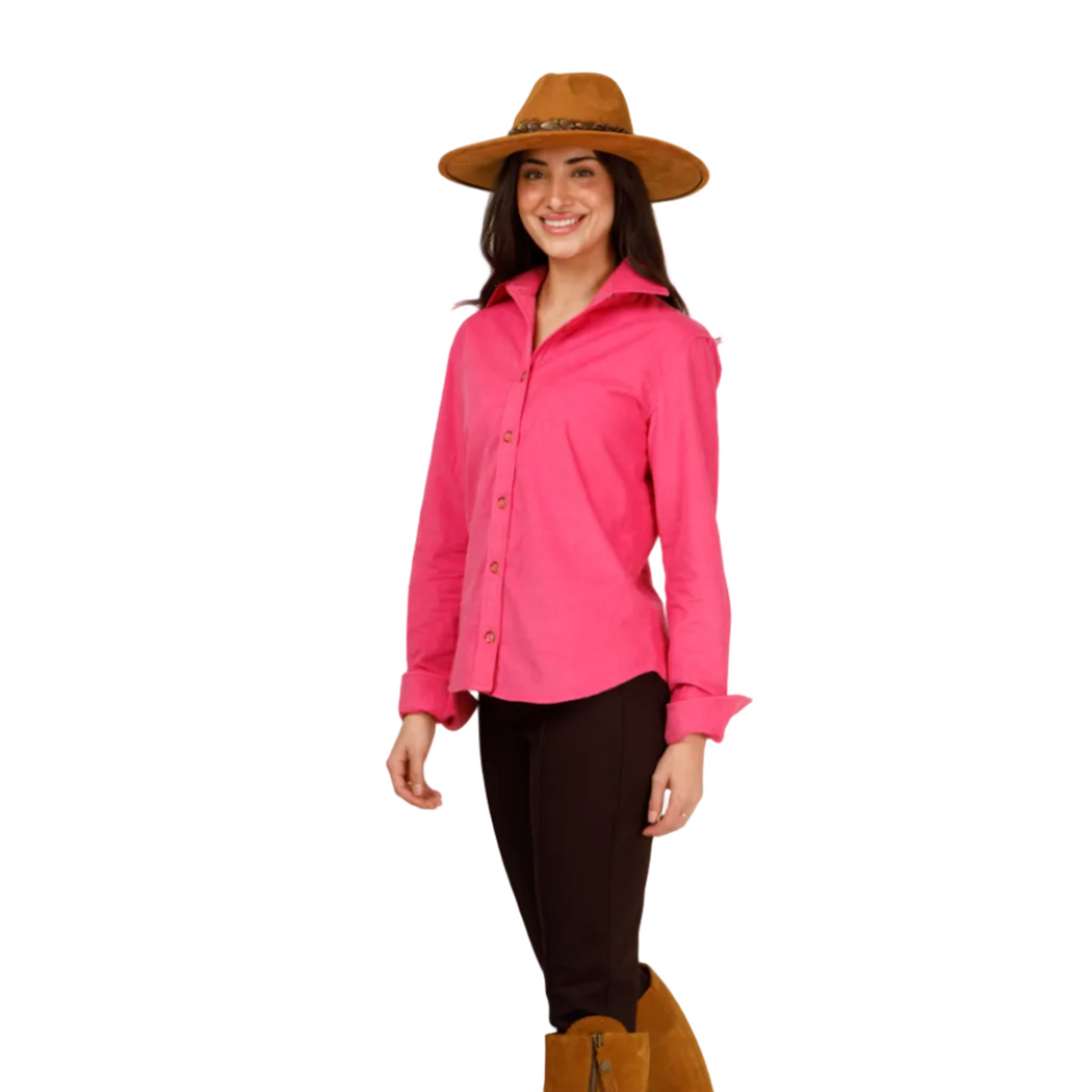 A woman modeling a bright pink long-sleeve button-up shirt, dark brown fitted pants, a brown wide-brim hat, and tan knee-high boots against a plain light gray studio background.