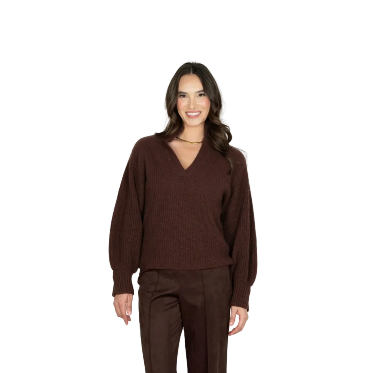 A woman modeling a dark brown ribbed knit sweater with a V-neck and balloon sleeves, paired with matching brown trousers, against a light gray studio background.