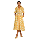 A woman modeling a yellow and white patterned midi shirt dress with a matching belt, standing against a plain white background.