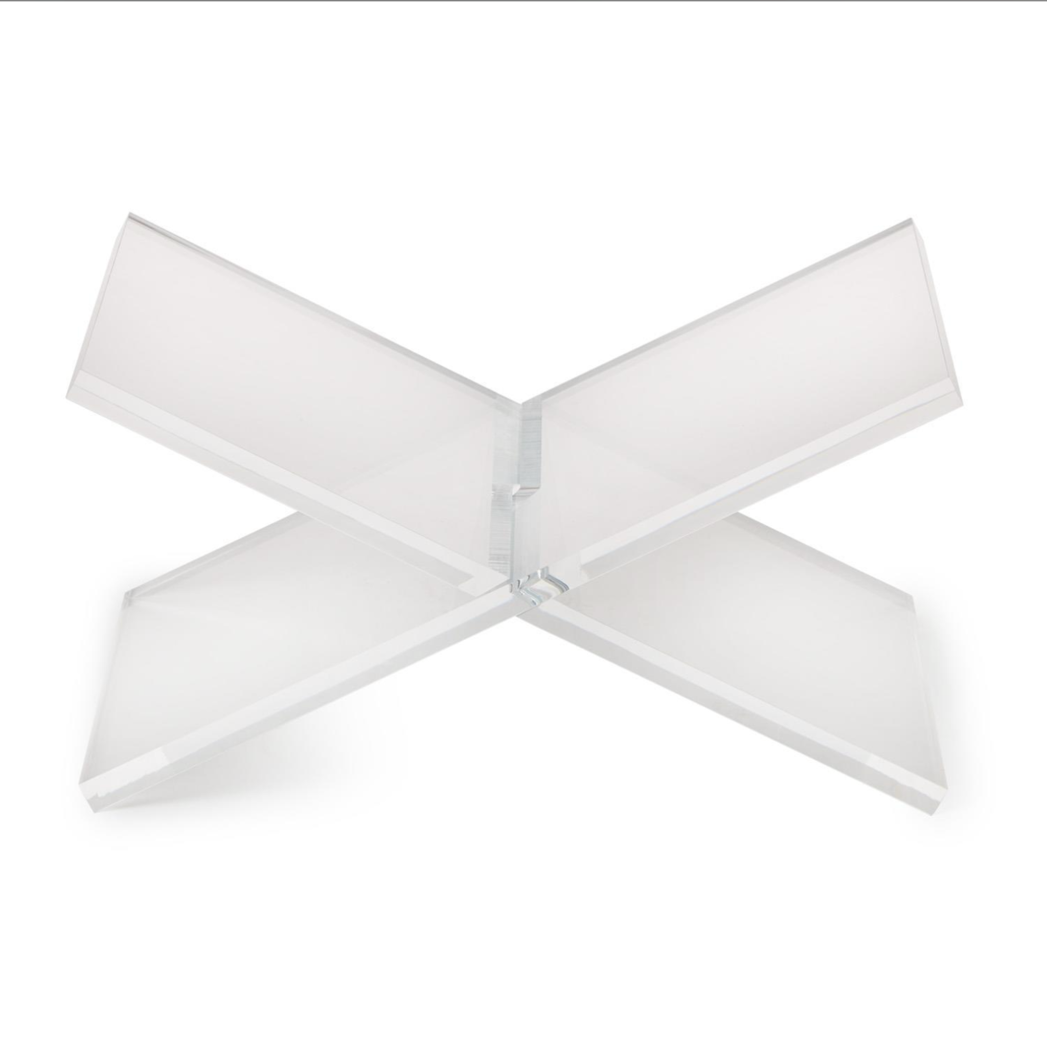 A modern, minimalist X-shaped acrylic or glass tabletop lamp shade on a solid white background.