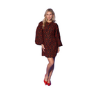 A woman modeling a short black coat with a red geometric pattern, featuring voluminous bell sleeves and a round neckline, set against a solid blue studio background.