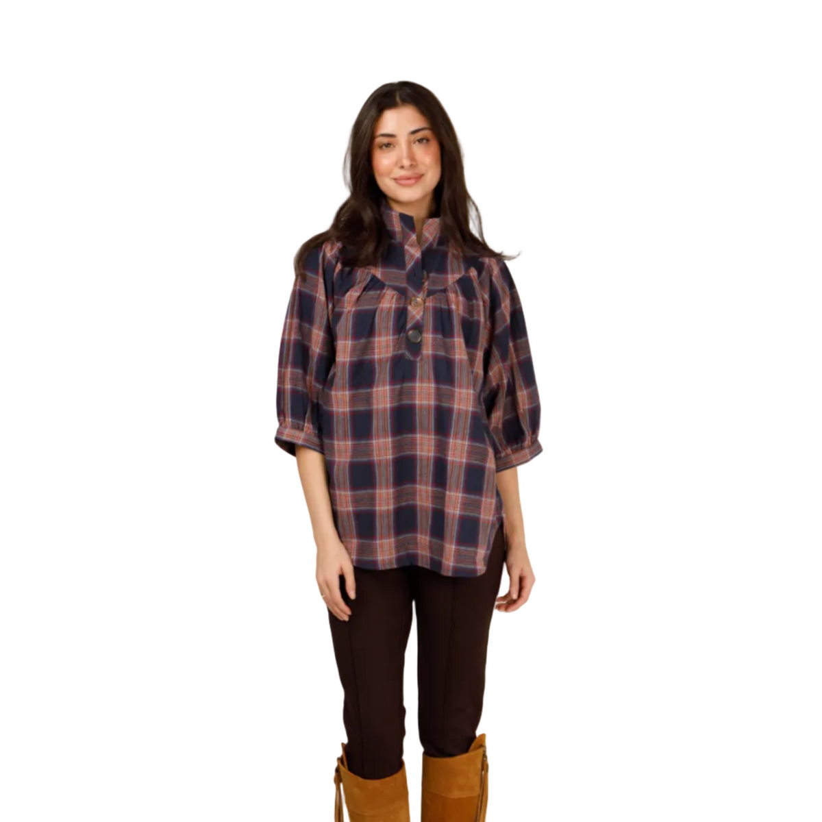 A woman modeling a plaid button-up shirt with three-quarter sleeves, paired with dark brown pants and tall tan suede boots, against a plain white studio background.