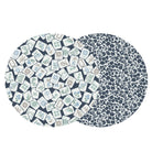 Two overlapping circular fabric swatches on a white background, showing navy blue patterns: one with scattered illustrated playing cards and one with a dense floral damask print.