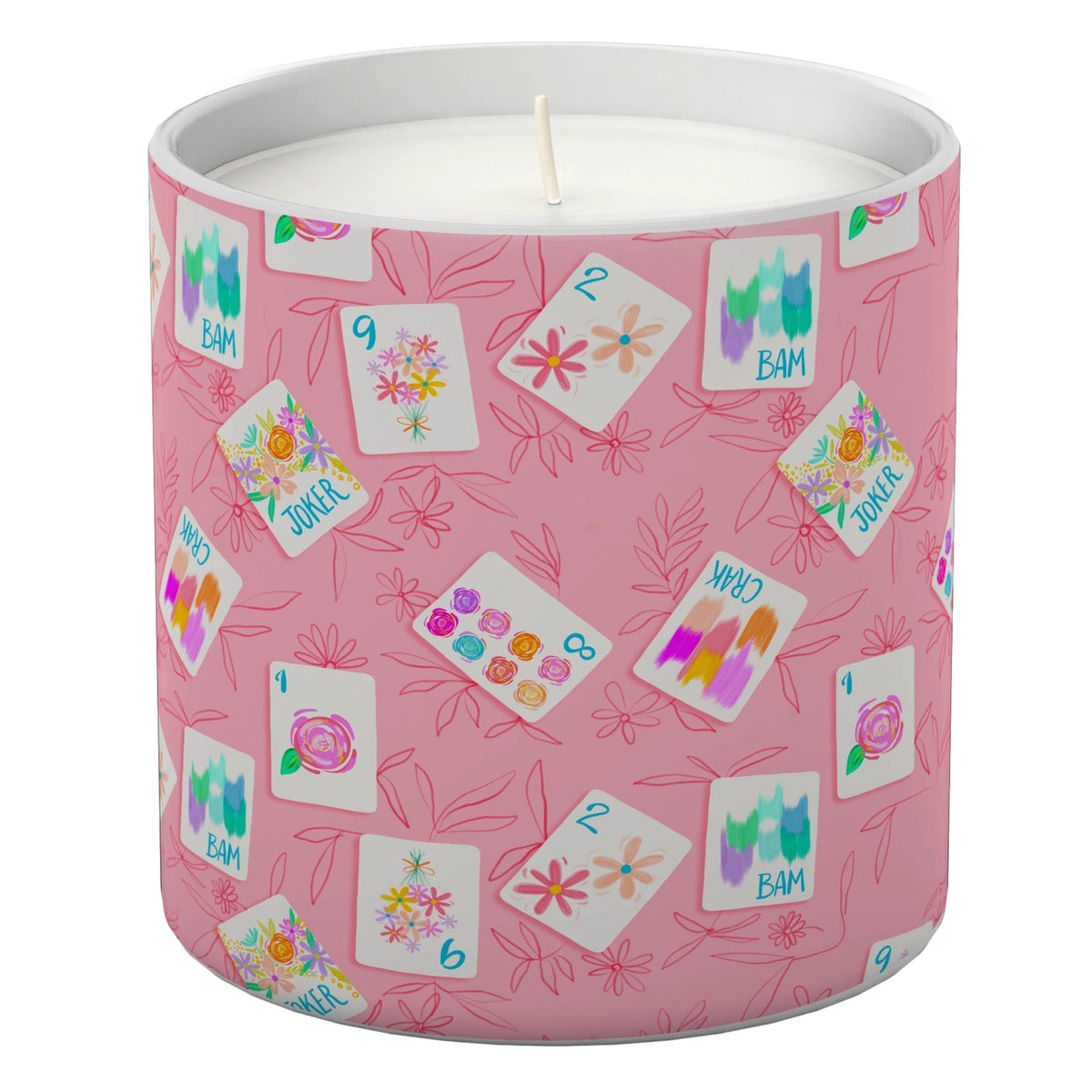 A pink cylindrical candle with a printed pattern of playing cards and floral illustrations, shown on a clean white background.