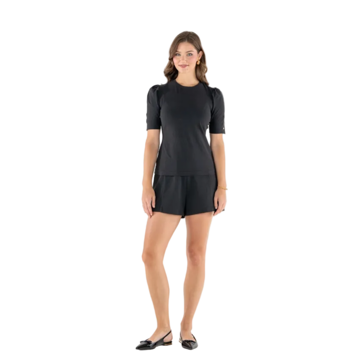 A woman modeling a black short-sleeve top and matching black shorts against a plain white studio background.