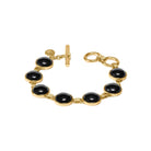 Gold bracelet with black stones on a white background