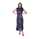 A woman modeling a sleeveless, high-neck midi dress with a colorful abstract print in pink, green, blue, and yellow on a black base, paired with bright pink heels, set against a solid blue studio background.