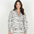 A woman modeling a matching long-sleeve V-neck top and wide-leg pants set in a gray and white zebra print, photographed against a light gray studio background.