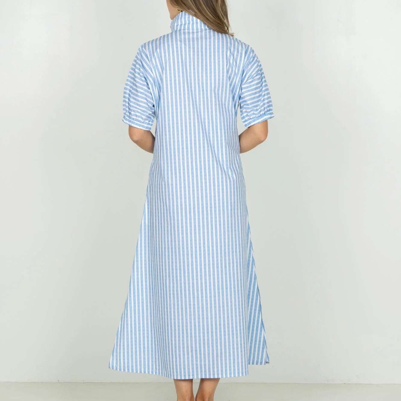 Woman wearing a blue and white striped dress on a white background
