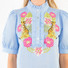 Light blue blouse with floral and seahorse embroidery on a plain background