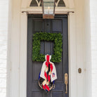 Decorative wreath with a ribbon on a black door