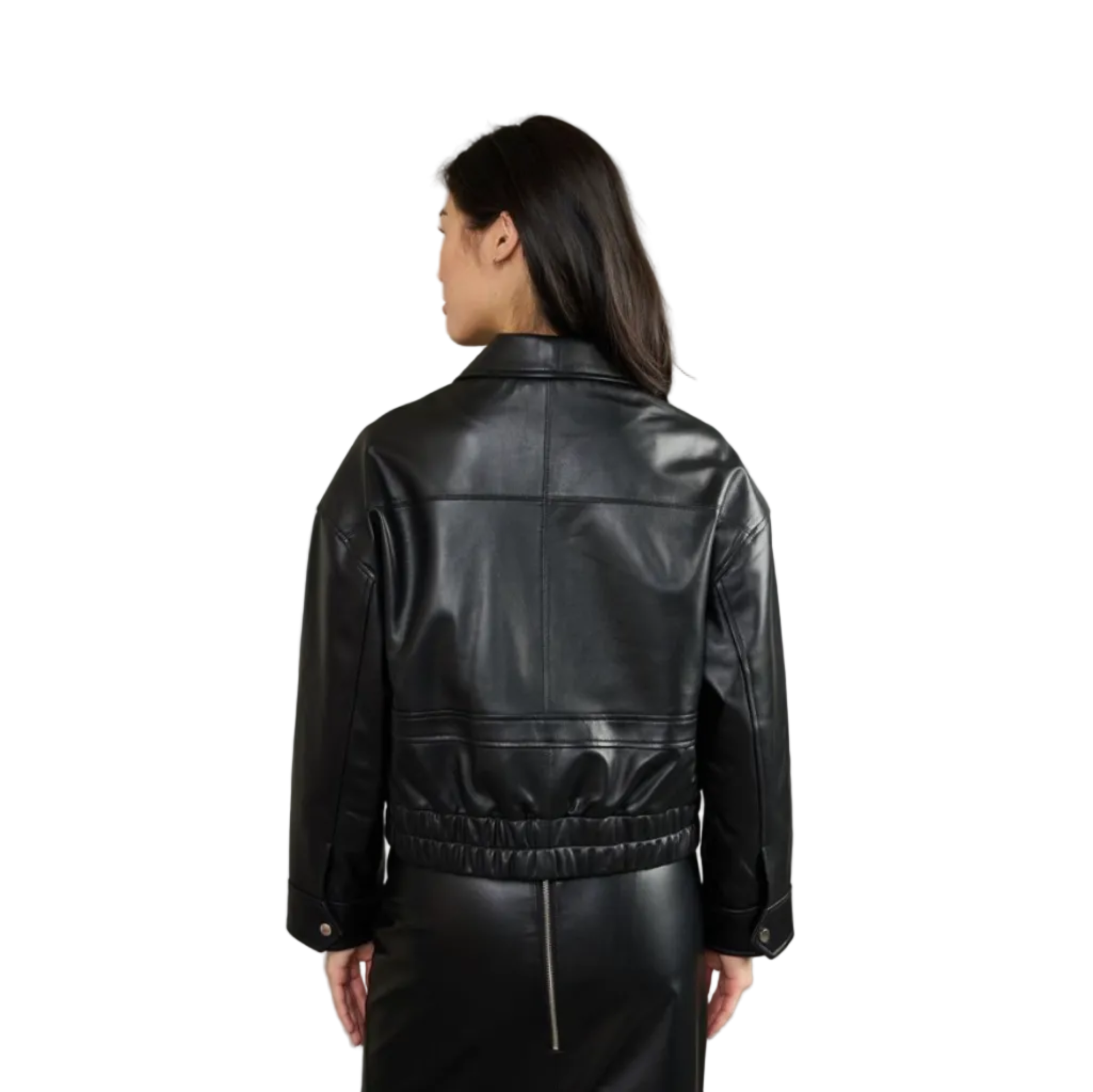 A woman shown from the back wearing a black leather cropped jacket with a gathered elastic waist and button cuffs, paired with a black skirt, against a solid gray studio background.