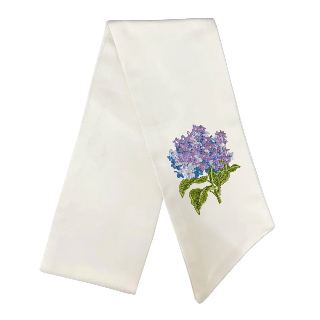 White towel with embroidered purple flower design on a white background