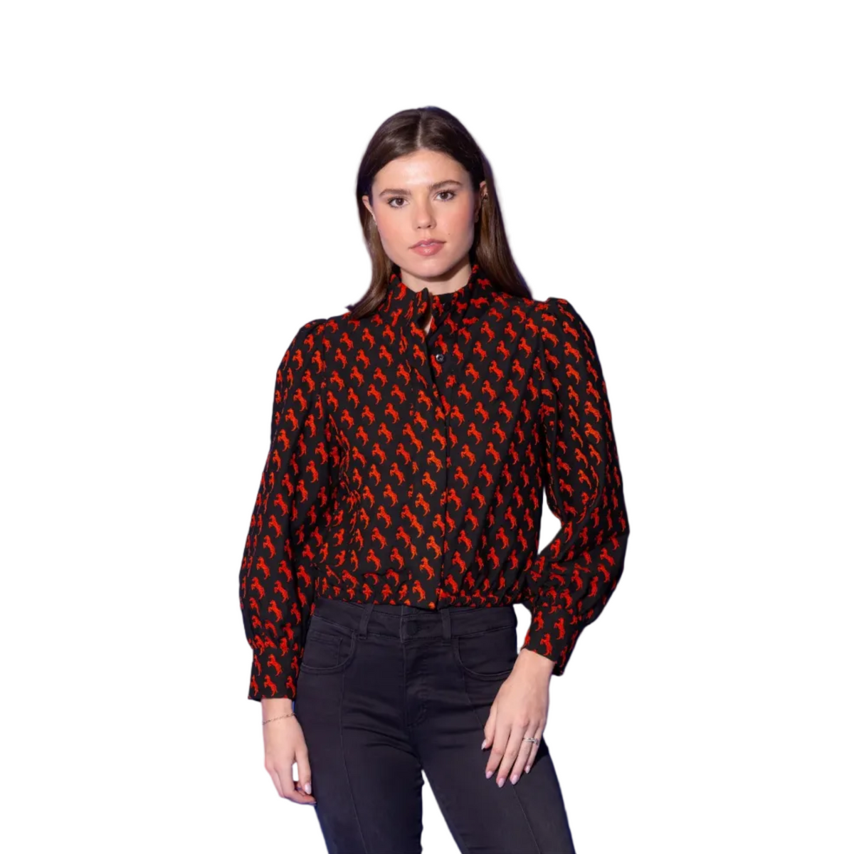 A woman modeling a long-sleeve button-up blouse with a black base and a repeating red abstract pattern, paired with black jeans, set against a solid blue studio background.