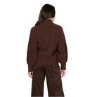 A model shown from the back wearing a dark brown ribbed knit mock-neck sweater and matching dark brown wide-leg trousers against a light gray studio background.