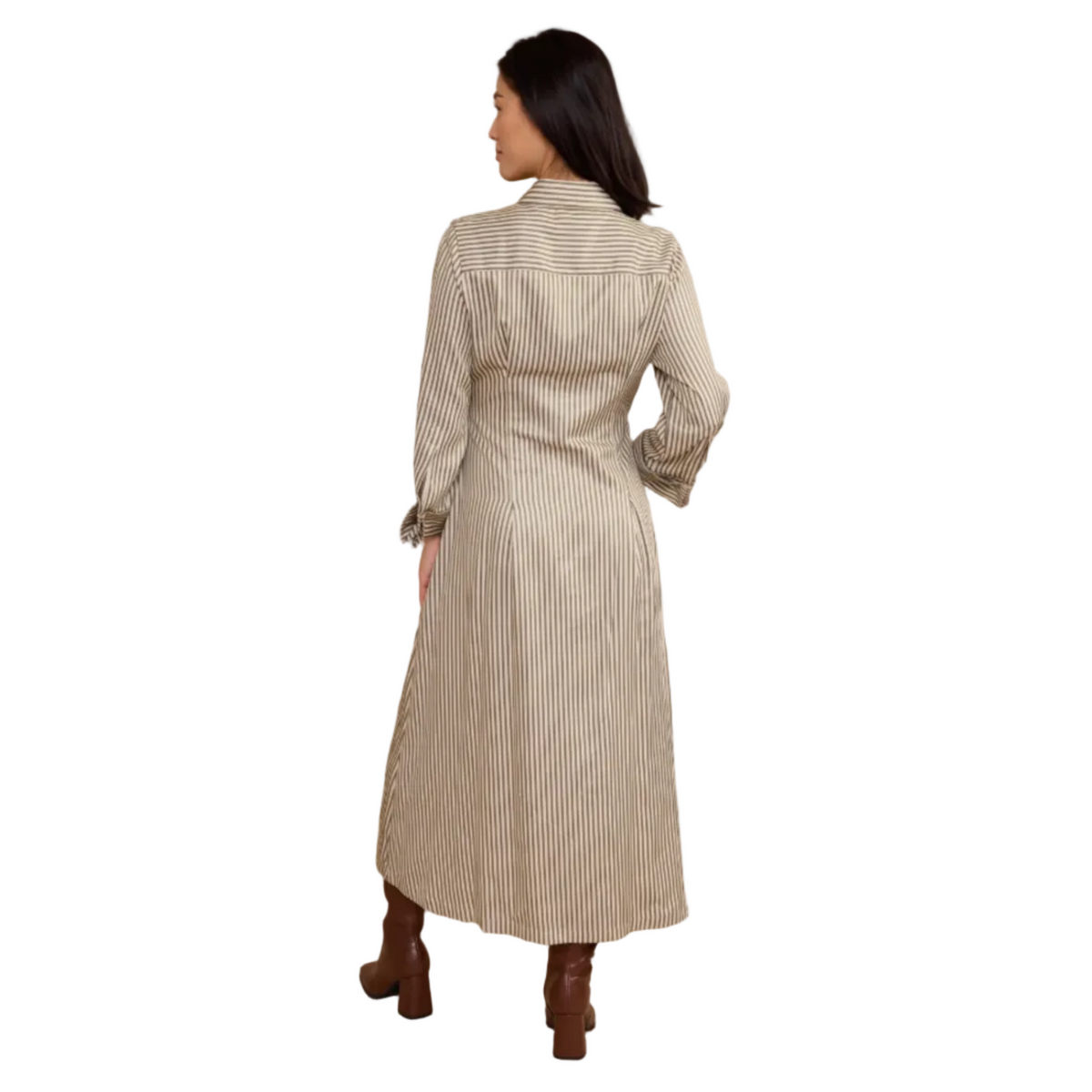 A woman is shown from the back wearing a long-sleeve, collared midi shirt dress with thin vertical stripes, paired with brown boots, against a solid beige studio background.