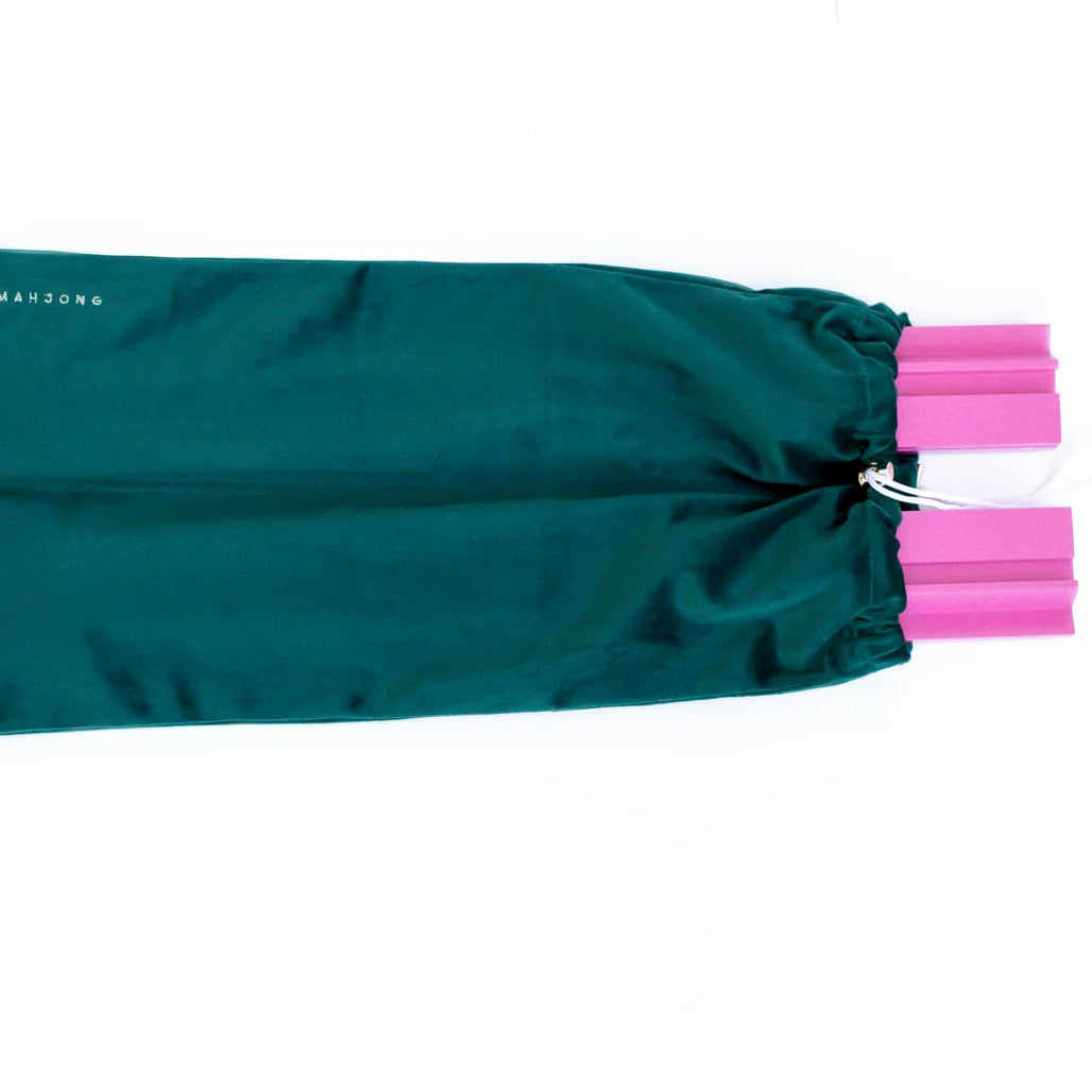 Green drawstring bag with pink ties on a white background