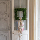 Green wreath with a ribbon on a white door