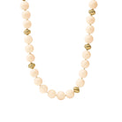 A beaded necklace with large pale cream beads and a few textured gold spacer beads, photographed on a clean white background.