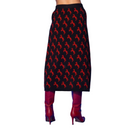 A black midi skirt with a repeating red horse pattern, shown from the back on a model wearing red boots against a solid blue background.