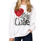 Woman wearing a white sweatshirt with a red heart and black text on a white background