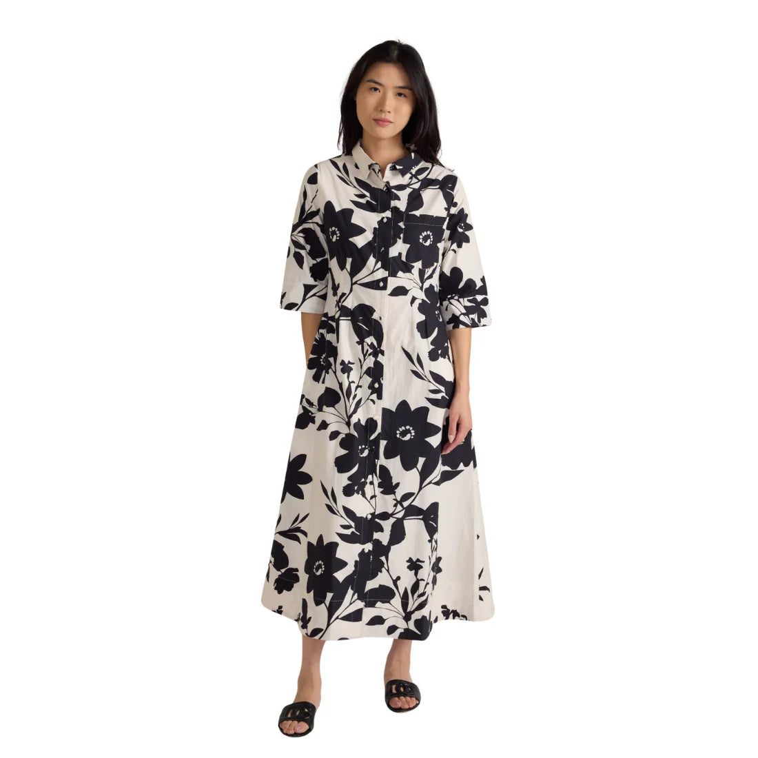 Woman wearing a black and white floral dress on a white background